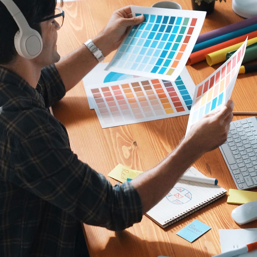 Business strategy: designer reviewing color swatches to build cohesive brand identity through strategic design choices